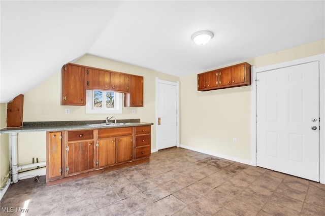 2142 W 95th St, Cleveland, OH 44102 - kitchen featuring a sink, brown cabinetry, dark countertops, and vaulted ceiling
