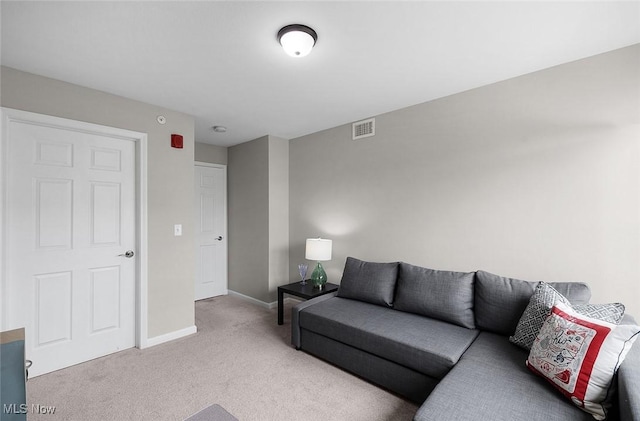 living area featuring light carpet and baseboards