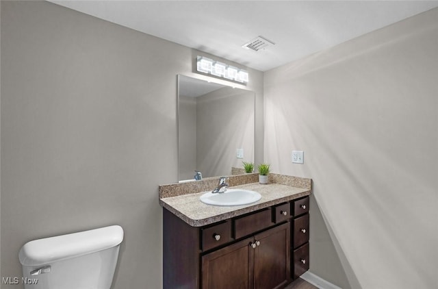 half bathroom with toilet and vanity