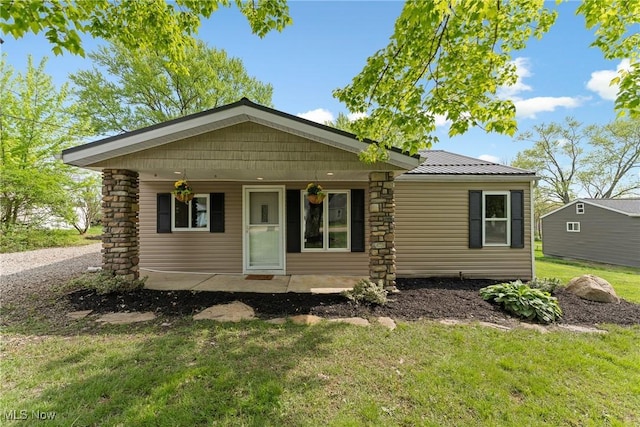 548 51st St SW, Canton, OH 44706 - view of front of house with a front lawn, metal roof, and covered porch