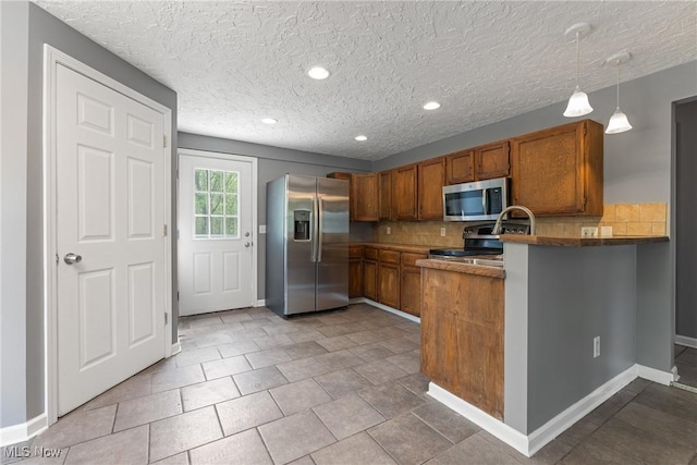 548 51st St SW, Canton, OH 44706 - kitchen featuring stainless steel appliances, brown cabinetry, a peninsula, decorative backsplash, and baseboards