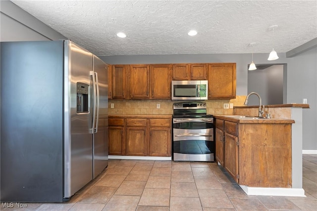 548 51st St SW, Canton, OH 44706 - kitchen featuring stainless steel appliances, a peninsula, a sink, brown cabinets, and decorative backsplash