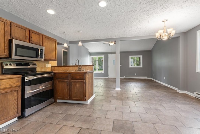 548 51st St SW, Canton, OH 44706 - kitchen with appliances with stainless steel finishes, baseboard heating, a peninsula, a sink, and open floor plan