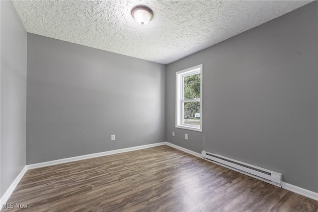 548 51st St SW, Canton, OH 44706 - empty room with baseboard heating, wood finished floors, baseboards, and a textured ceiling