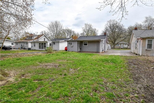 rear view of property with a yard