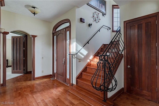 425 Woodside Ave, Jefferson, OH 44047 - entryway with arched walkways, wood finished floors, stairs, and baseboards