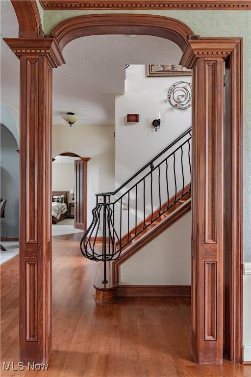 425 Woodside Ave, Jefferson, OH 44047 - stairs featuring arched walkways, decorative columns, wood finished floors, and baseboards