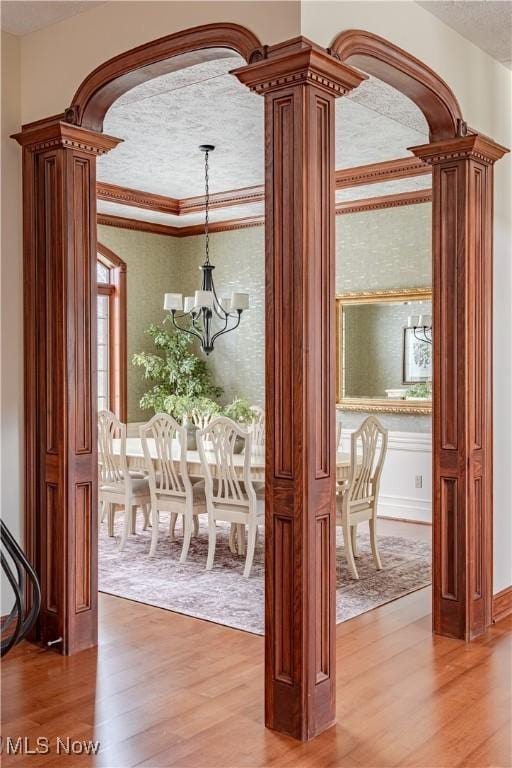 425 Woodside Ave, Jefferson, OH 44047 - doorway to outside with light wood-style floors, a chandelier, wallpapered walls, arched walkways, and crown molding