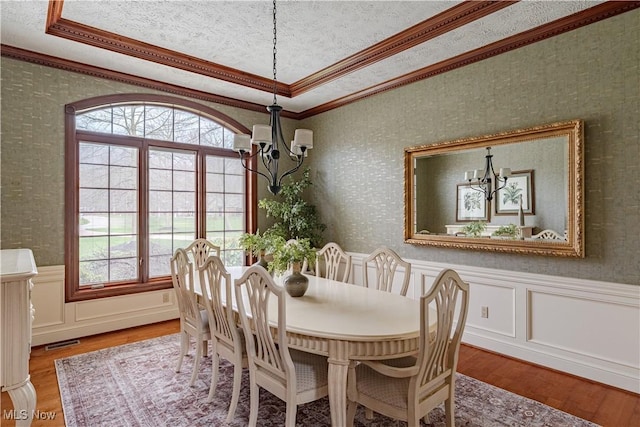 425 Woodside Ave, Jefferson, OH 44047 - dining room featuring wallpapered walls, crown molding, wood finished floors, a tray ceiling, and a wainscoted wall