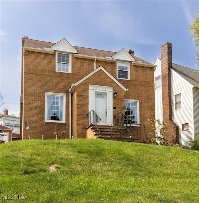 multi unit property with brick siding and a front yard