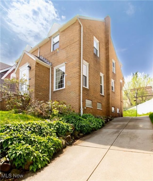 view of side of property with brick siding and fence