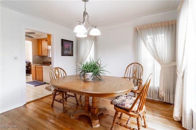 dining room with light wood finished floors and a chandelier