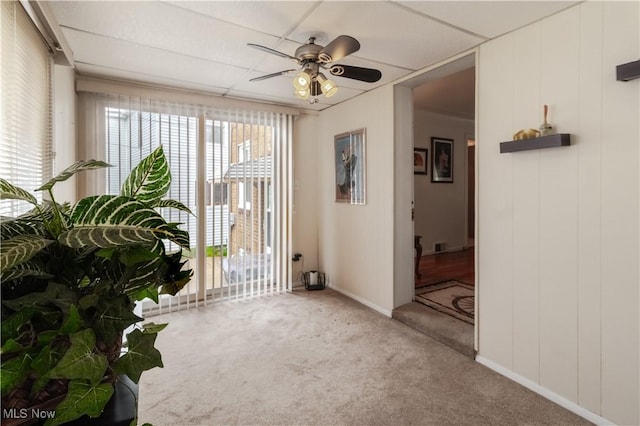 unfurnished room featuring carpet floors, a ceiling fan, and baseboards