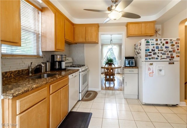 kitchen with white appliances, a sink, tasteful backsplash, a ceiling fan, and healthy amount of natural light