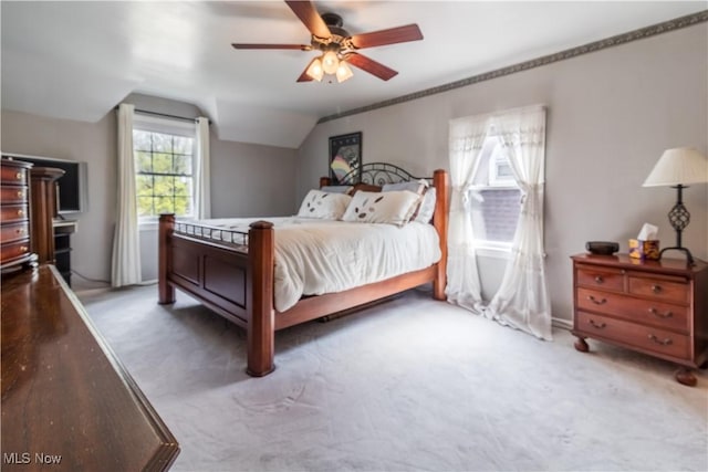 bedroom with lofted ceiling, a ceiling fan, and carpet flooring