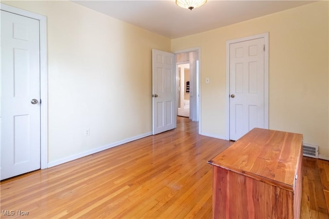 unfurnished bedroom with baseboards and light wood-type flooring