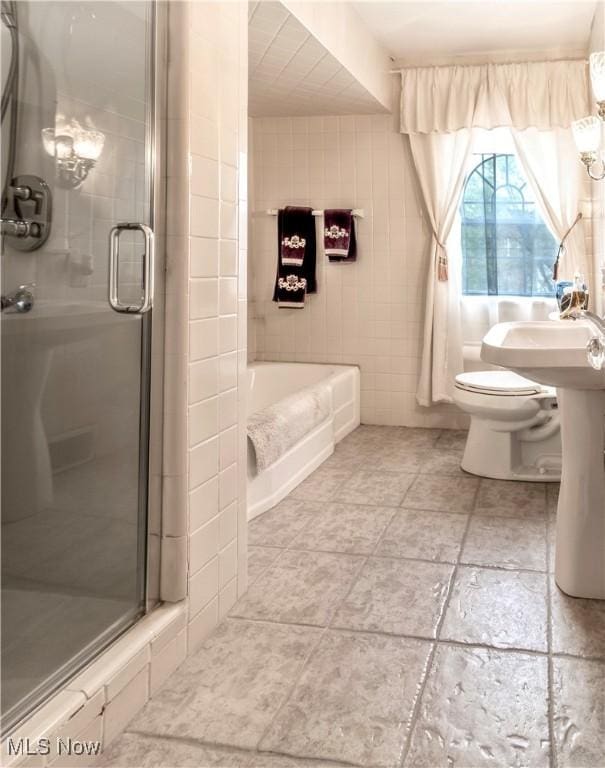 bathroom featuring tile walls, toilet, a stall shower, a bath, and tile patterned floors