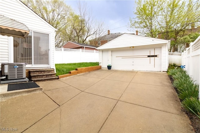 detached garage featuring cooling unit and fence