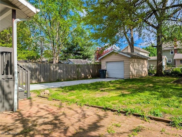 view of yard featuring an outdoor structure, driveway, and a garage