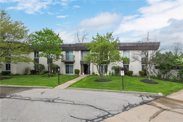 townhome / multi-family property featuring a balcony and brick siding