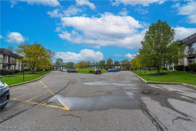 view of asphalt street featuring curbs and a residential view