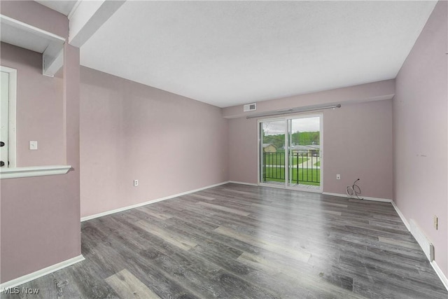 empty room featuring wood finished floors and baseboards