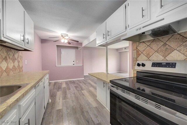 kitchen with stainless steel electric range, under cabinet range hood, backsplash, a ceiling fan, and light countertops