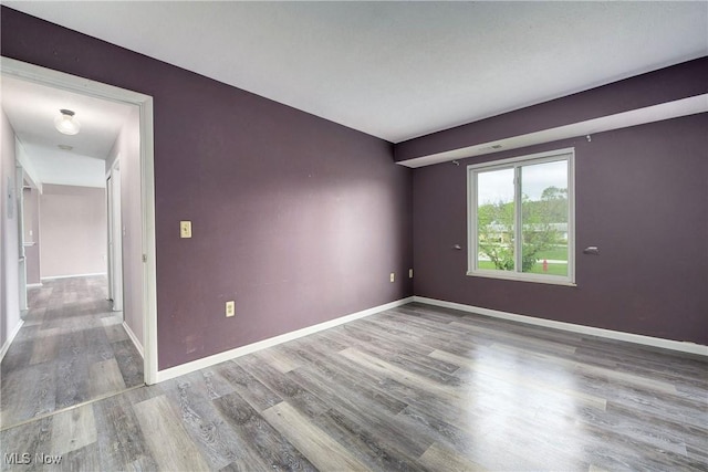 spare room with wood finished floors and baseboards