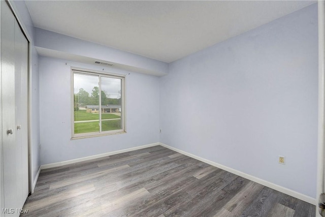unfurnished room with wood finished floors and baseboards