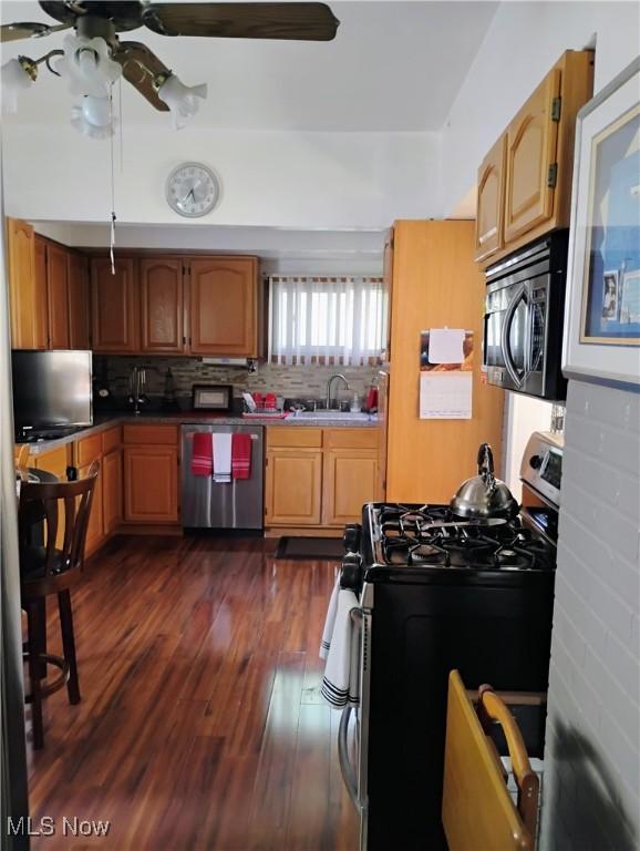 13418 Coath Ave, Cleveland, OH 44120 - kitchen featuring stainless steel appliances, a sink, a ceiling fan, dark wood-style flooring, and tasteful backsplash