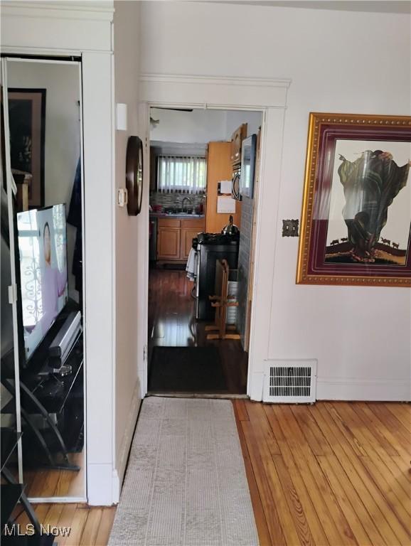 13418 Coath Ave, Cleveland, OH 44120 - hall featuring wood finished floors, baseboards, and a sink