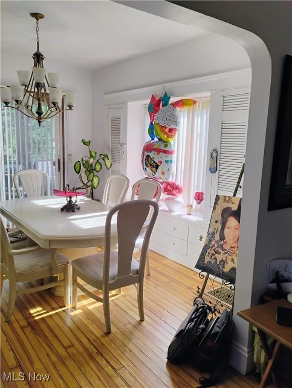 13418 Coath Ave, Cleveland, OH 44120 - dining space featuring a chandelier, light wood-type flooring, and arched walkways