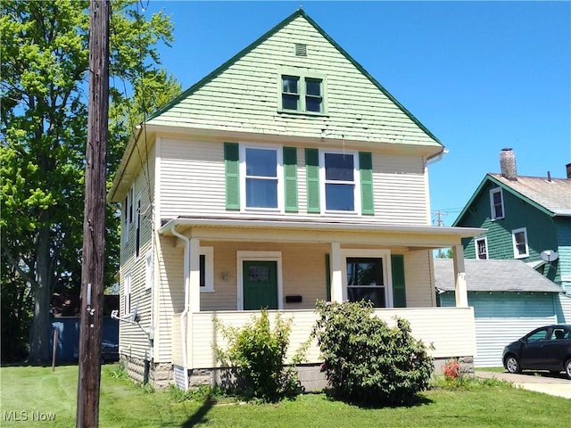 american foursquare style home with covered porch and a front lawn