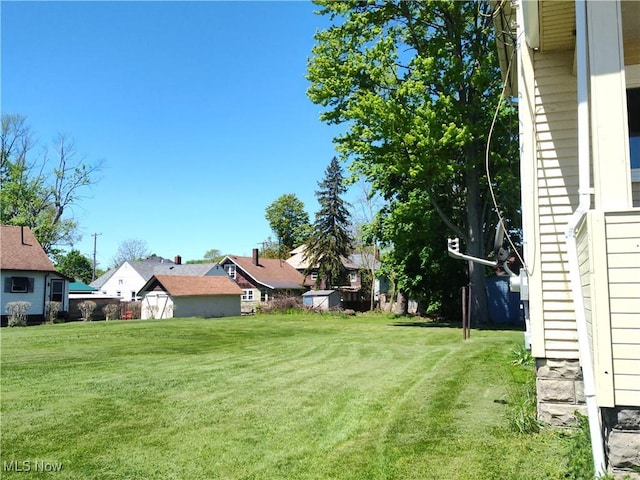 view of grassy yard featuring a residential view