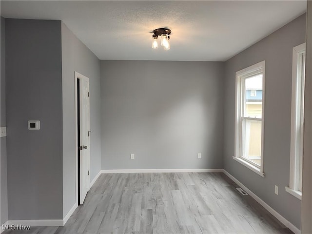 unfurnished room with light wood finished floors and baseboards