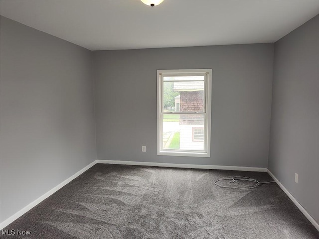 spare room featuring carpet flooring and baseboards