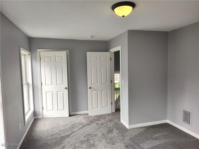 unfurnished bedroom featuring carpet flooring and baseboards