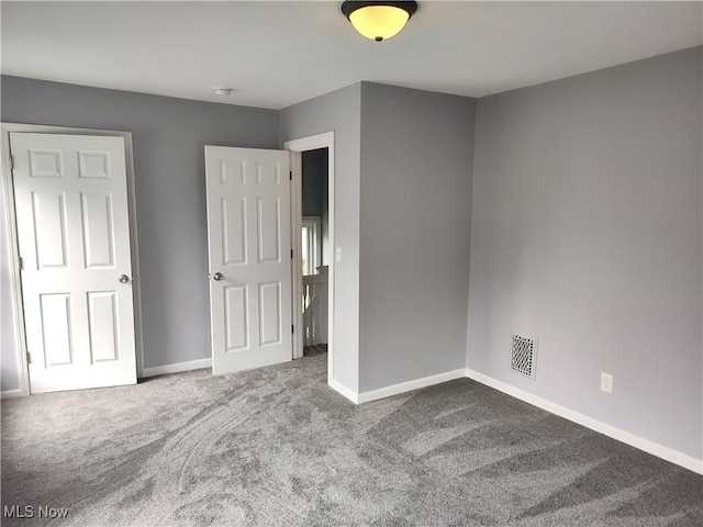 unfurnished bedroom featuring carpet flooring and baseboards