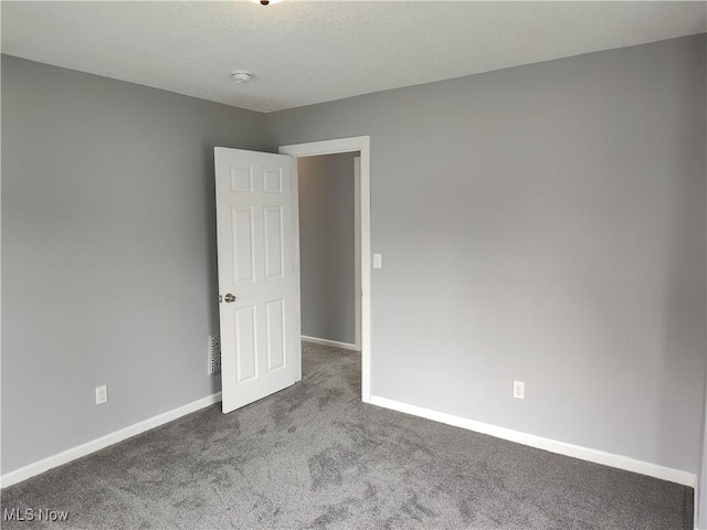 carpeted empty room featuring baseboards