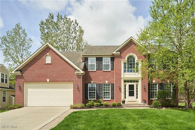 1284 Spafford Dr, Copley, OH 44321 - view of front of house featuring concrete driveway, a front yard, a garage, and brick siding