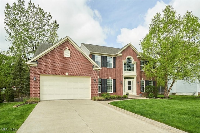 1284 Spafford Dr, Copley, OH 44321 - view of front of property with brick siding, driveway, a front lawn, and a garage