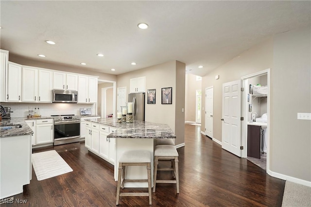 1284 Spafford Dr, Copley, OH 44321 - kitchen with stainless steel appliances, a sink, dark wood-type flooring, light stone counters, and recessed lighting