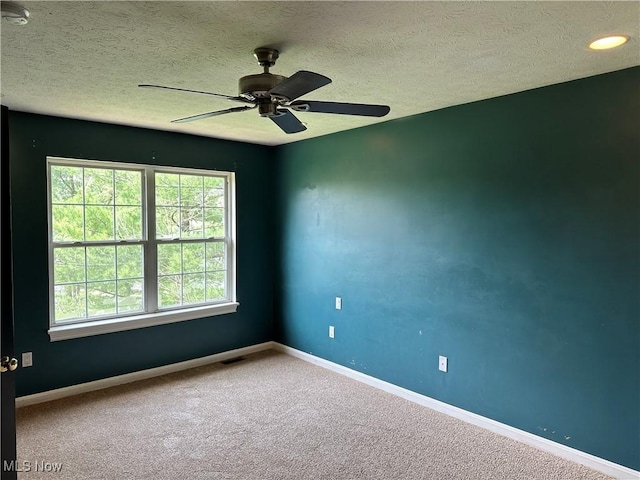 spare room featuring baseboards, a textured ceiling, carpet flooring, and a smoke detector