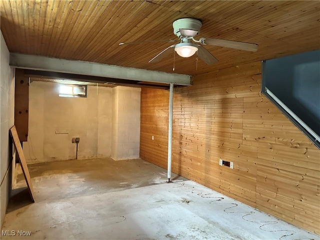 basement featuring wood walls and a ceiling fan