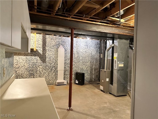 unfinished basement featuring heating unit
