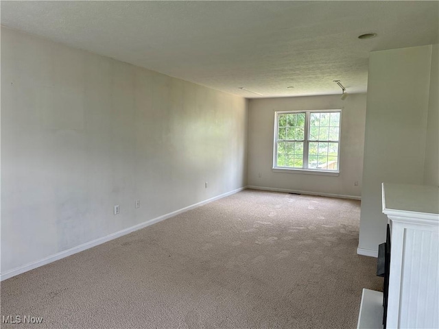 carpeted spare room featuring baseboards