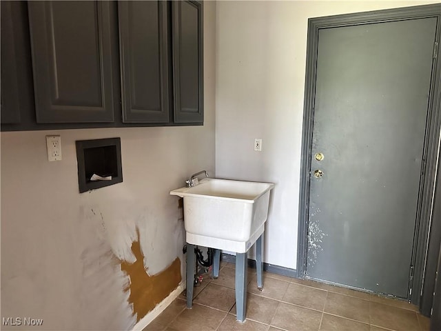 clothes washing area featuring cabinet space, tile patterned floors, and baseboards