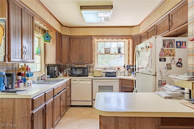 1056 Garman Rd, Akron, OH 44313 - kitchen featuring white appliances, a sink, light countertops, backsplash, and brown cabinetry