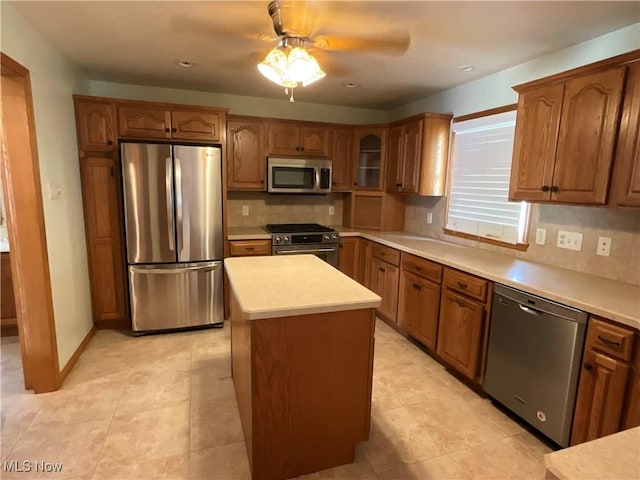 1245 Sageberry Dr, North Lima, OH 44452 - kitchen with stainless steel appliances, tasteful backsplash, brown cabinetry, and a ceiling fan