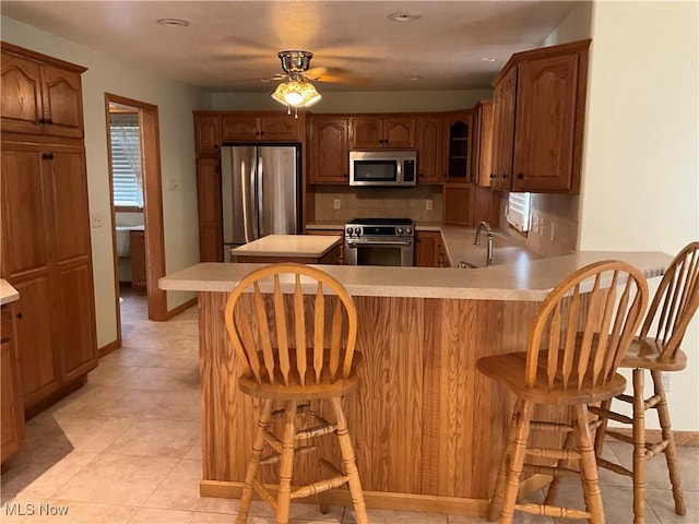 1245 Sageberry Dr, North Lima, OH 44452 - kitchen featuring stainless steel appliances, decorative backsplash, light countertops, a peninsula, and ceiling fan